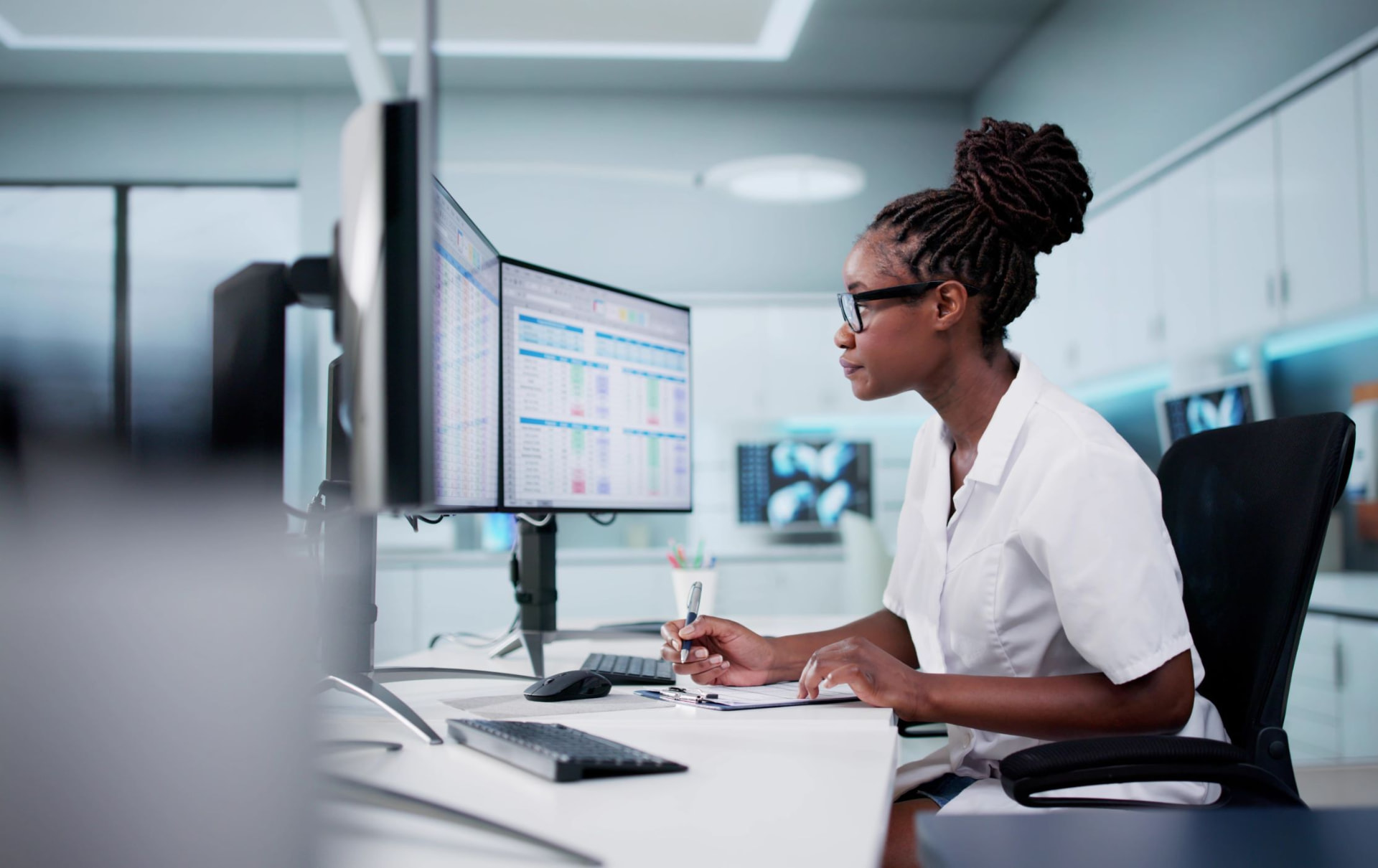 Healthcare administrator working at multiple monitors